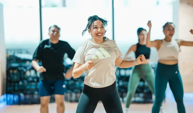 Smiling Participants Enjoying A Zumba Class At Gymnation